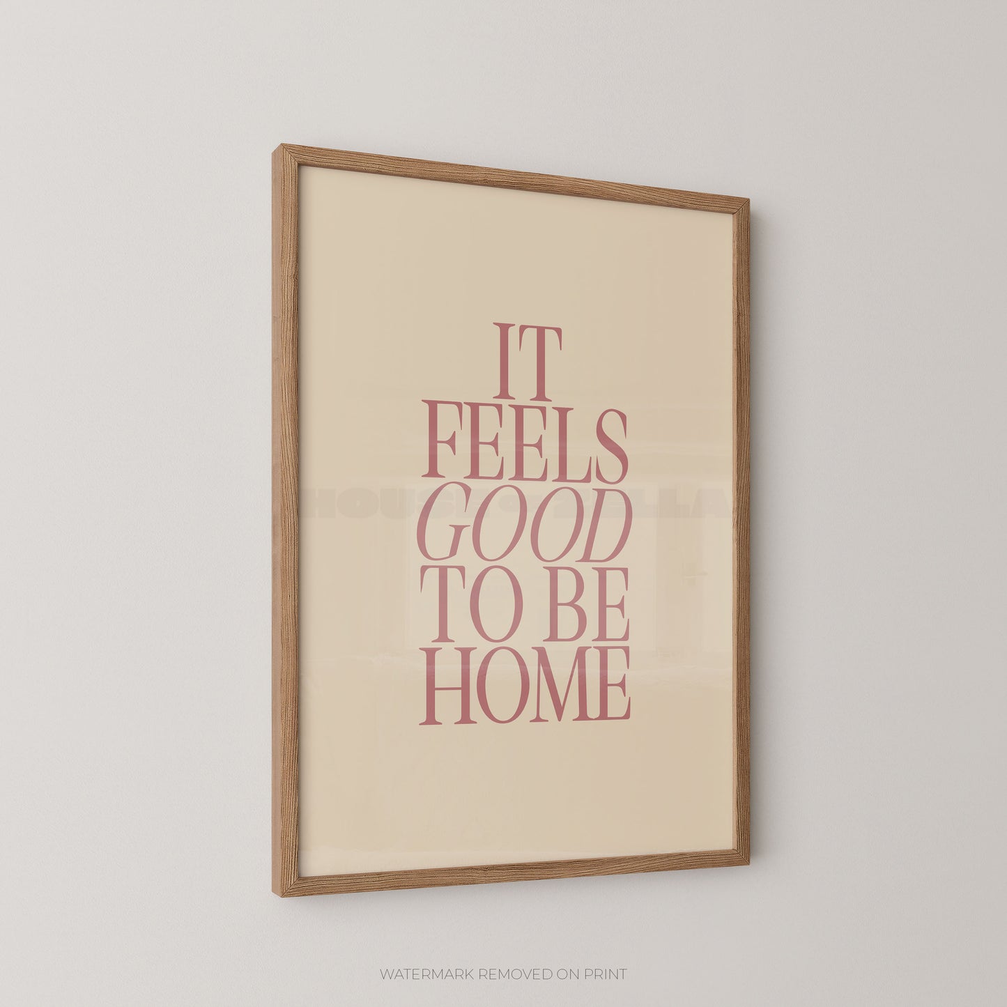 Framed poster with 'It Feels Good to Be Home' text on a beige background