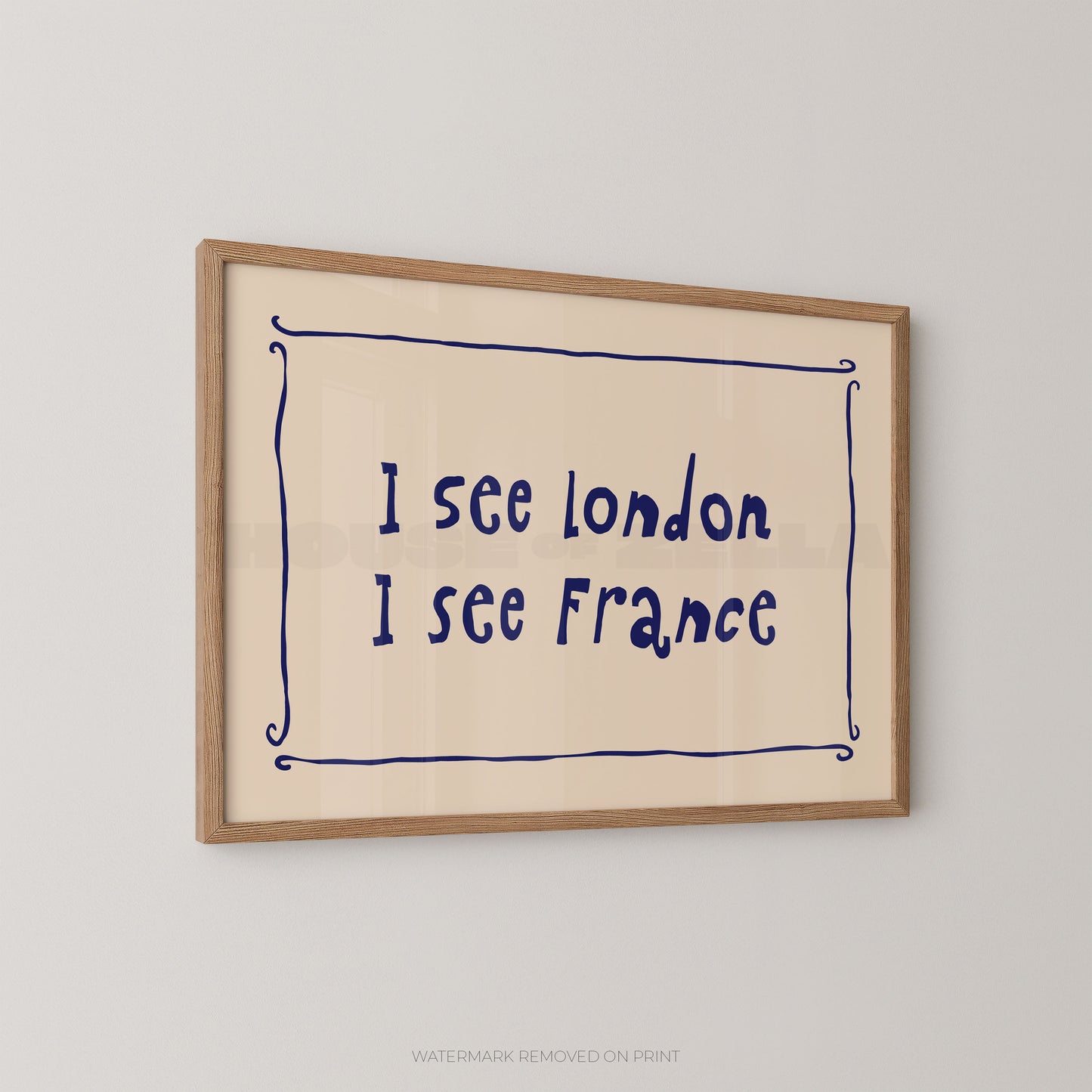 Framed wall art print with the handwritten text 'I see London I see France' in dark blue inside a light wood frame, shown hanging on a light gray wall.