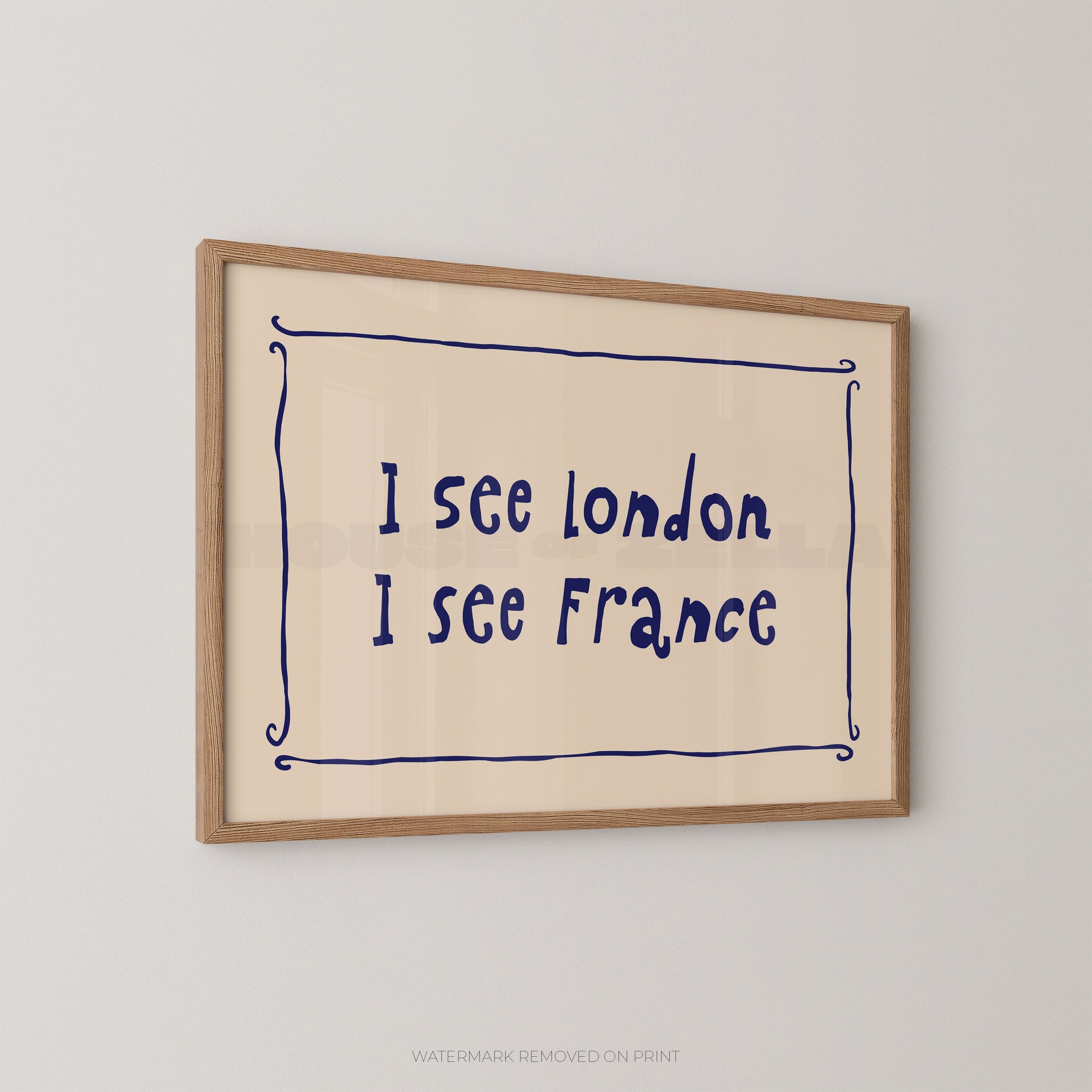 Framed wall art print with the handwritten text 'I see London I see France' in dark blue inside a light wood frame, shown hanging on a light gray wall.