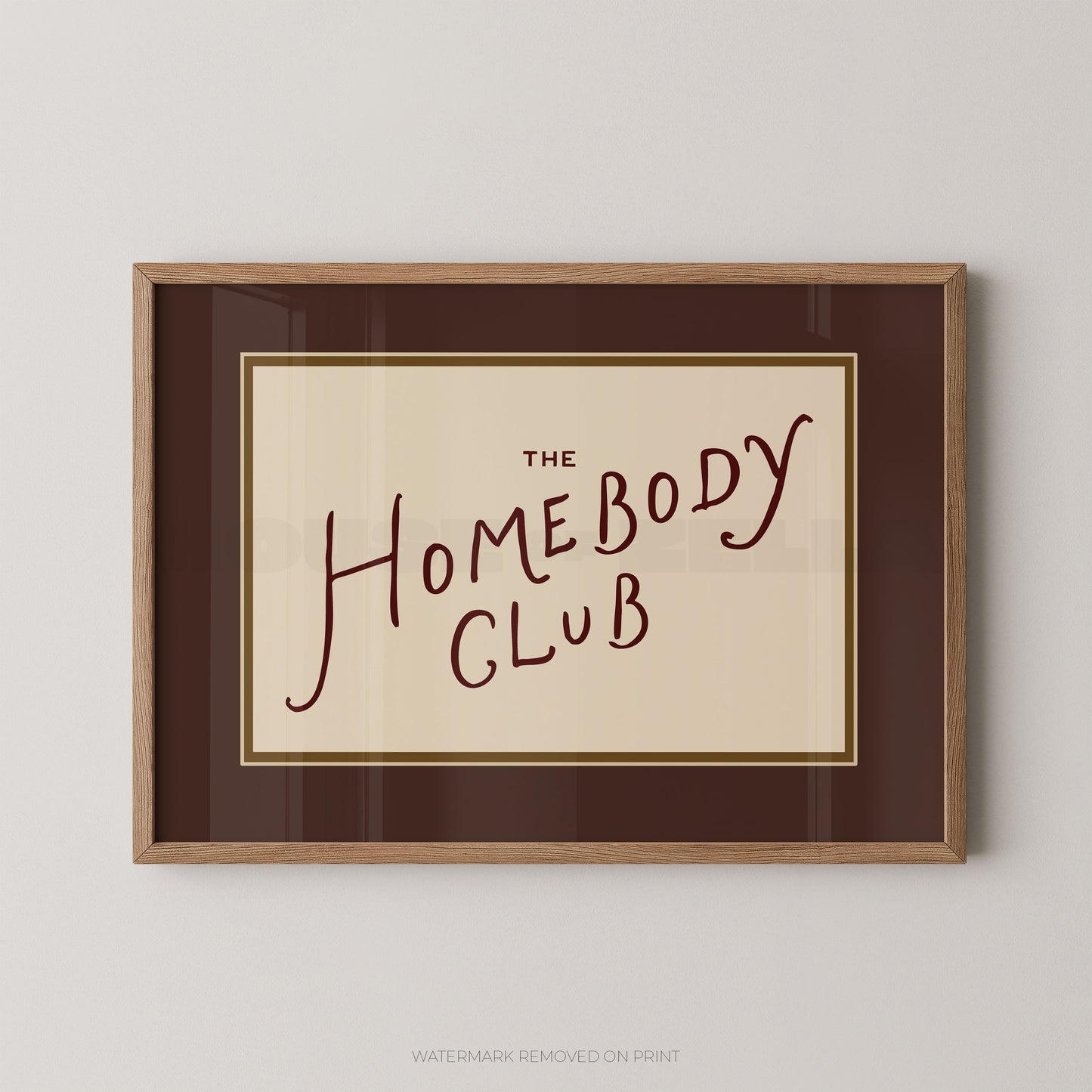 Framed print with 'The Homebody Club' text on a beige background