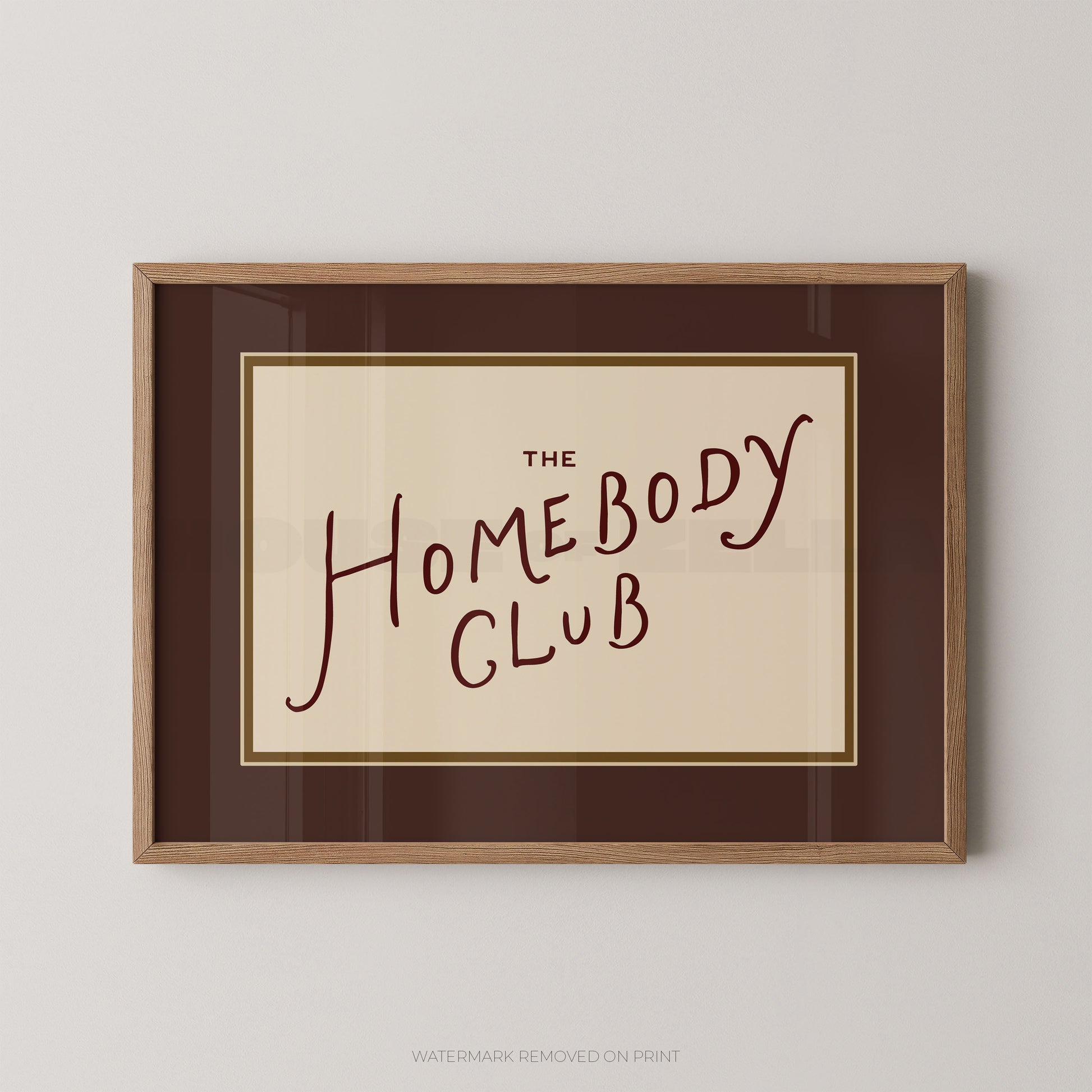 Framed print with 'The Homebody Club' text on a beige background