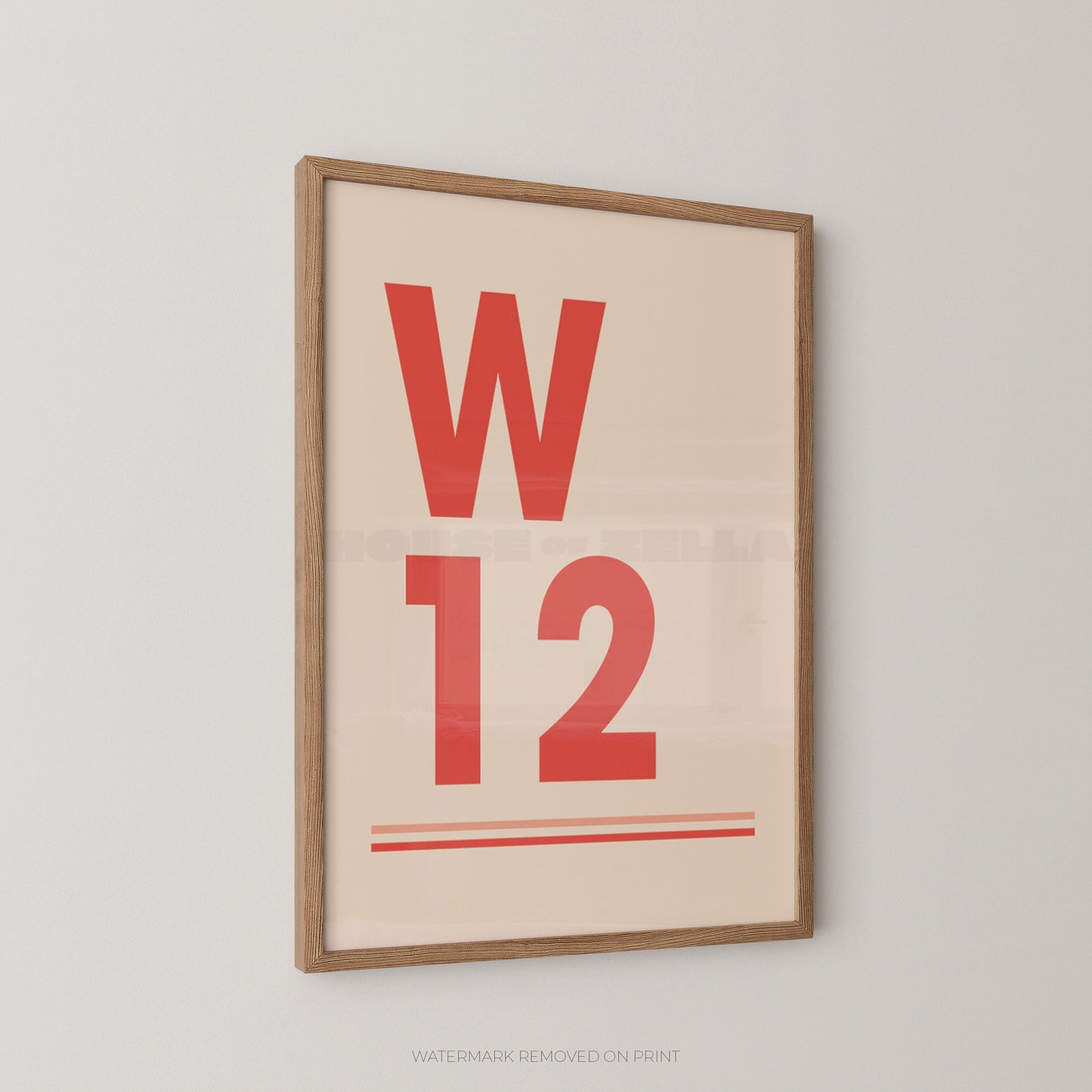 A framed minimalist typographic wall art print featuring a large red letter 'W' and the number '12' on a warm cream background, shown hanging on a light gray wall.