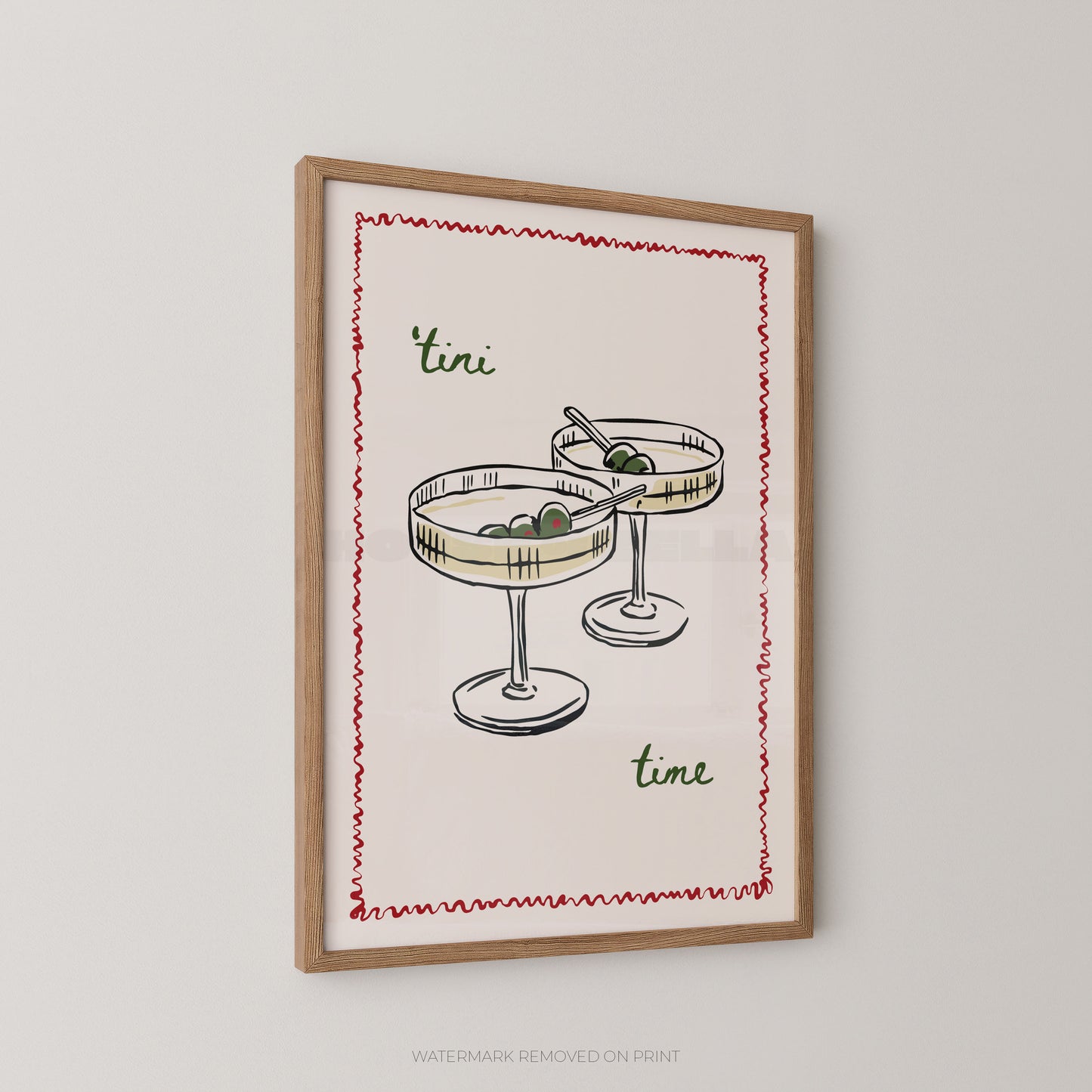Framed wall art print featuring a hand-drawn illustration of two margarita glasses with olives, bordered by a red zigzag line, with the words "tini time" in green script, shown hanging on a light gray wall.
