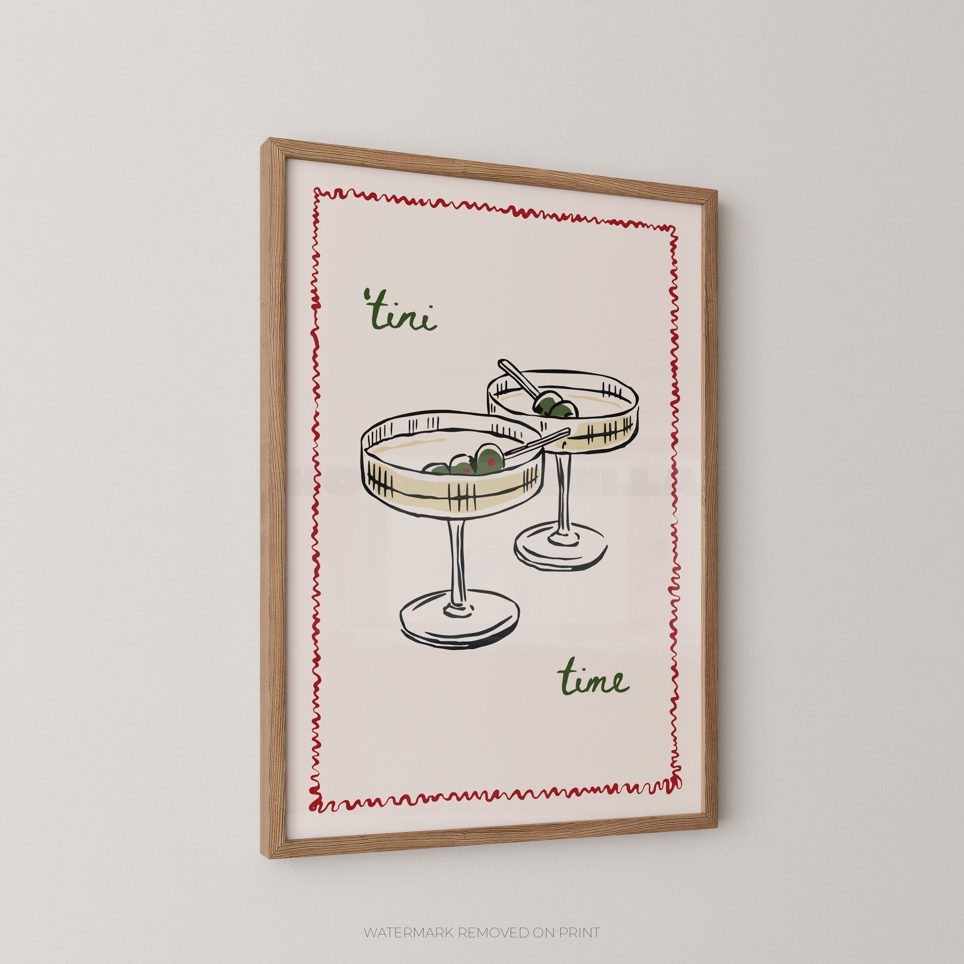 Framed wall art print featuring a hand-drawn illustration of two margarita glasses with olives, bordered by a red zigzag line, with the words "tini time" in green script, shown hanging on a light gray wall.