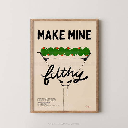 A framed typographic art print featuring a martini glass with green olives and the text 'MAKE MINE filthy' on a light beige background, shown against a light gray wall.