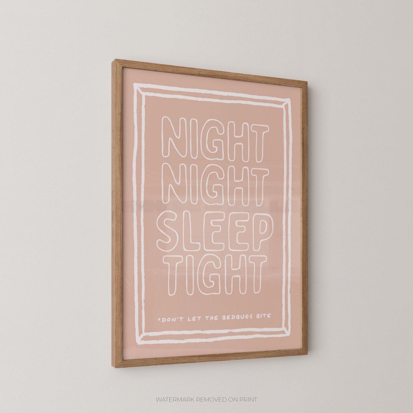 A framed typographic wall art print with the words “NIGHT NIGHT SLEEP TIGHT” in large outlined letters on a blush pink background, with smaller text reading “DON’T LET THE REDDRUSS BITE.” The print is shown hanging on a light neutral wall in a wood frame.