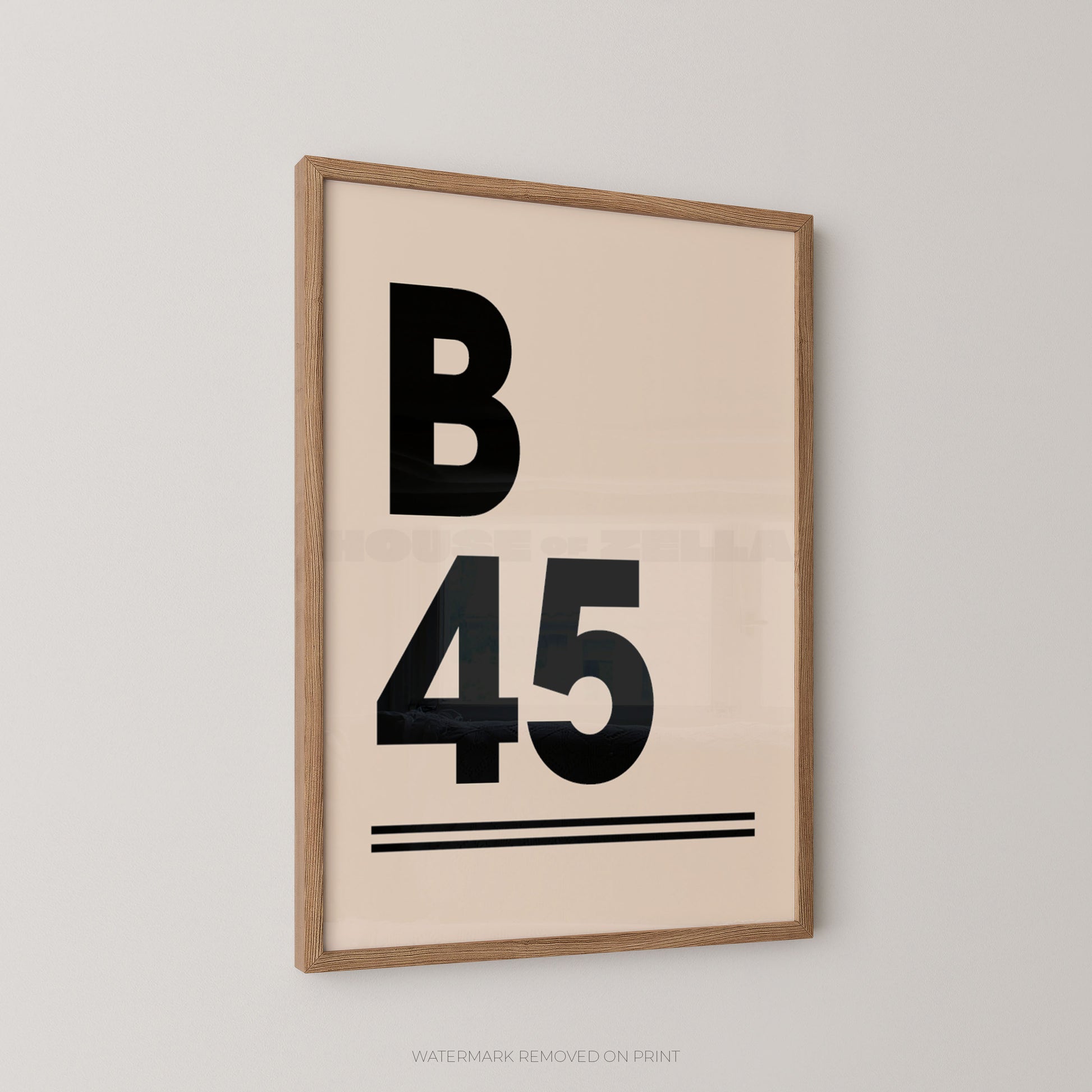 A wall art print in black and cream with a postcode displayed B45 personalised design in an oak frame hung on a pale wall.