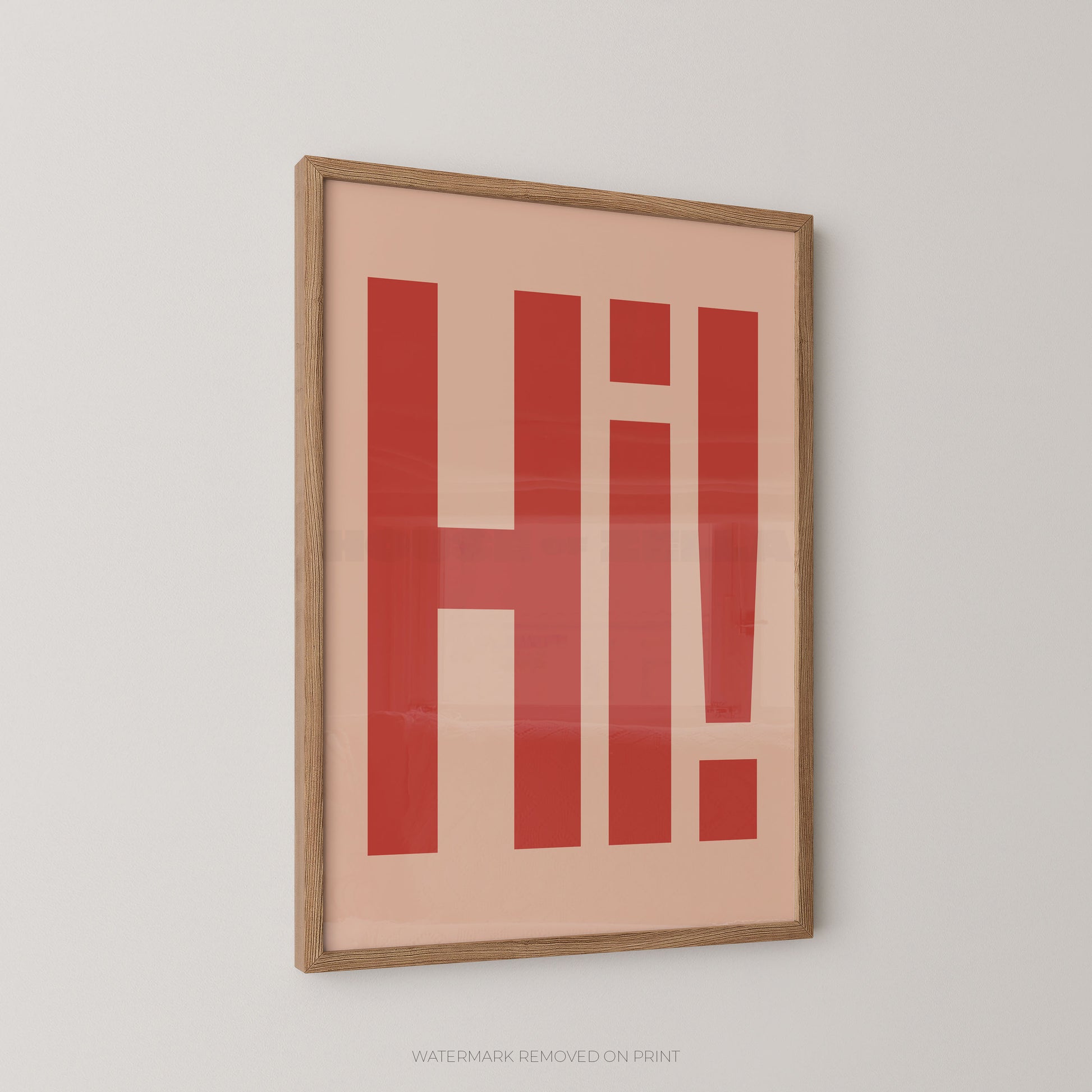 Framed typographic wall art featuring the word 'Hi!' in bold red letters on a warm peach background, enclosed in a light natural wood frame and shown hanging on a light gray wall.