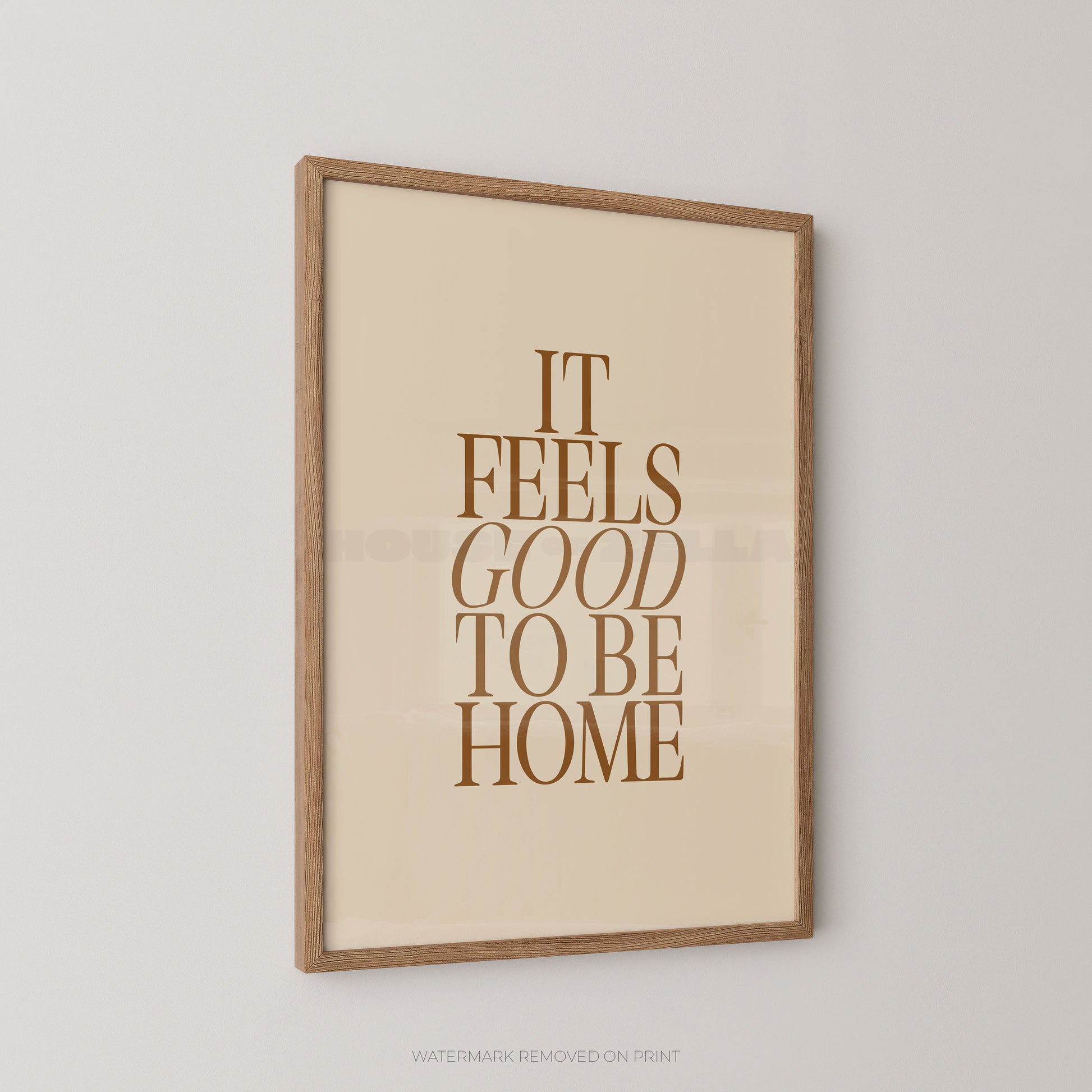 Framed print with 'It Feels Good to Be Home' text on a beige background
