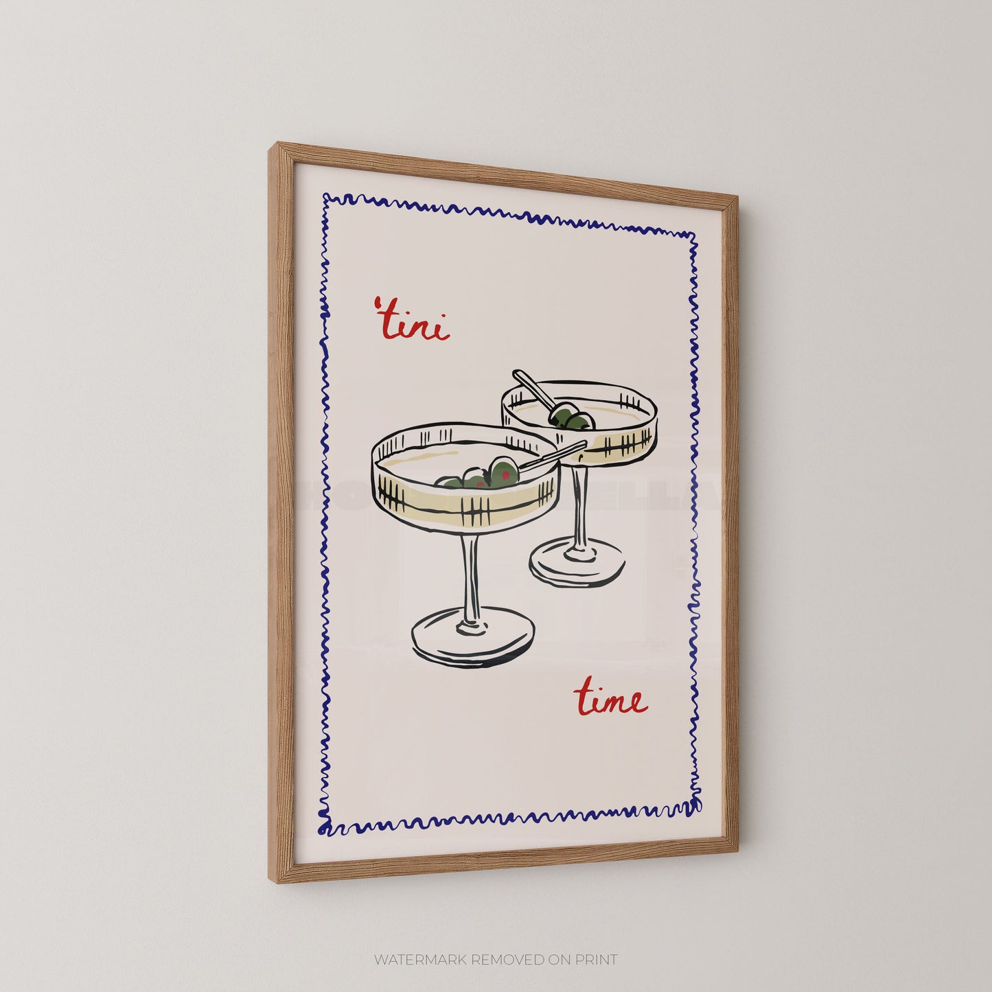 Framed wall art print featuring a hand-drawn illustration of two cocktail glasses with olives, bordered by a blue zigzag line, with the words "tini time" in red script, shown hanging on a light gray wall.
