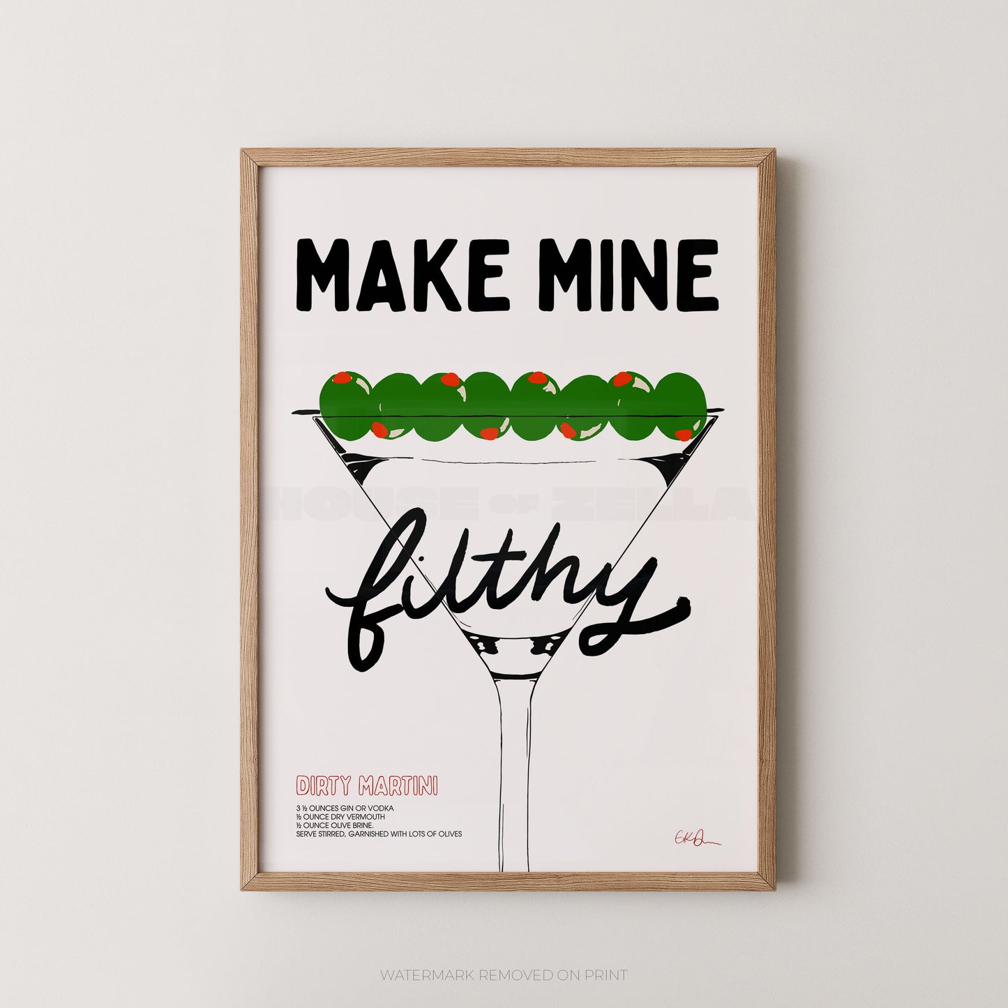 A framed typographic art print featuring a martini glass with green olives and the text 'MAKE MINE filthy' on a white background, shown hanging against a light gray wall.