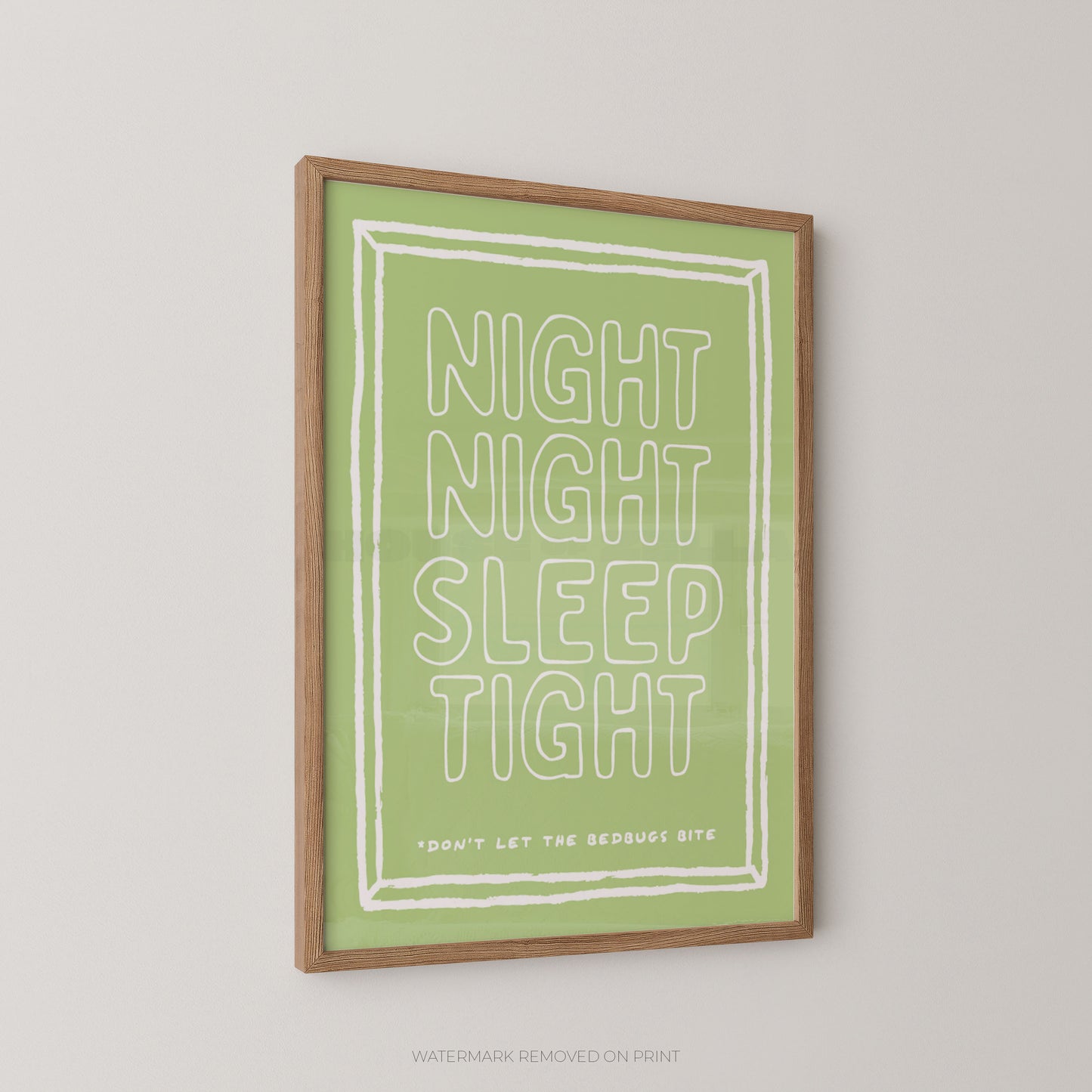 A framed art print with the text 'NIGHT NIGHT SLEEP TIGHT' in white outlined letters on a light green background, enclosed in a natural wood frame and shown against a light gray wall.