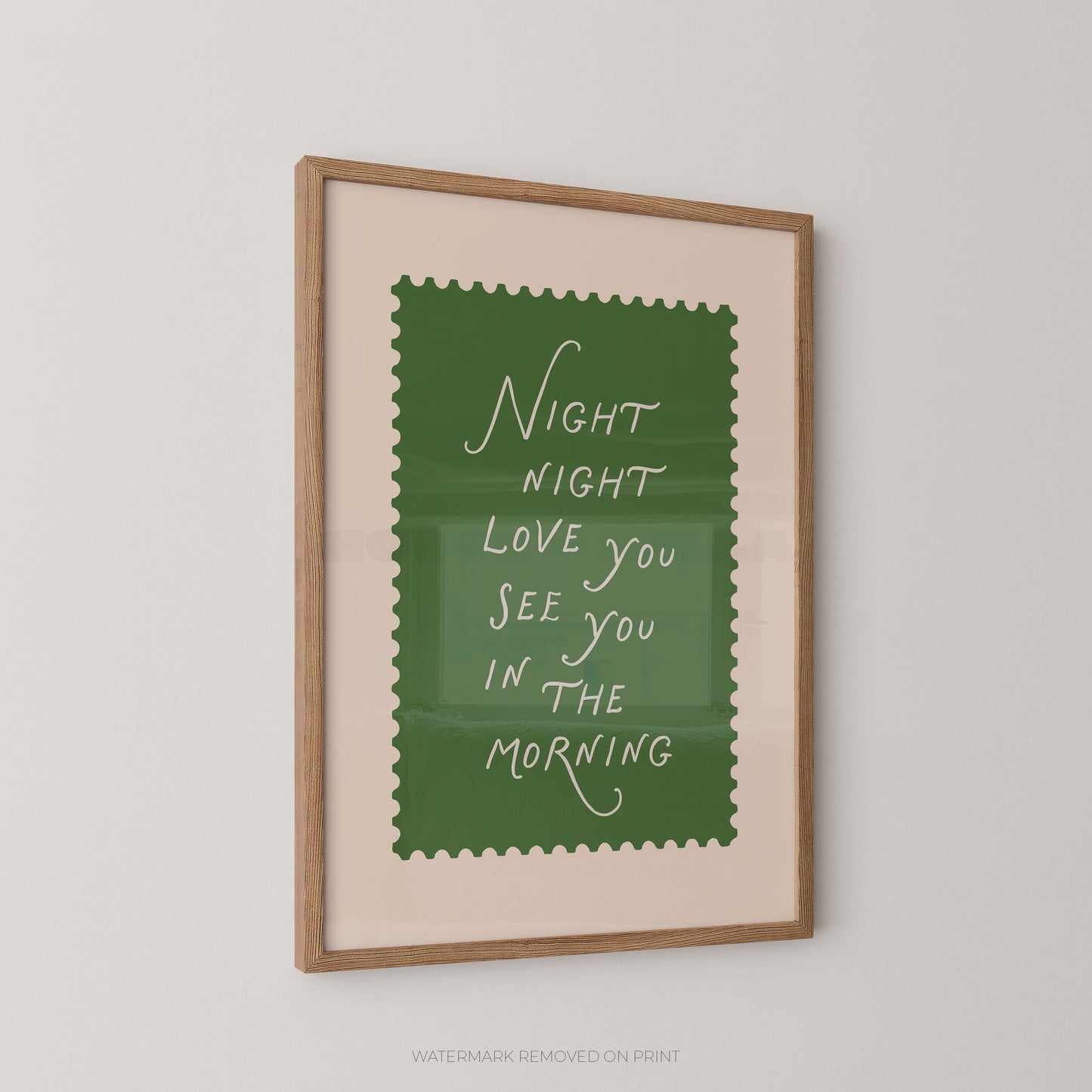 Framed print with a green background and white text on a beige wall.