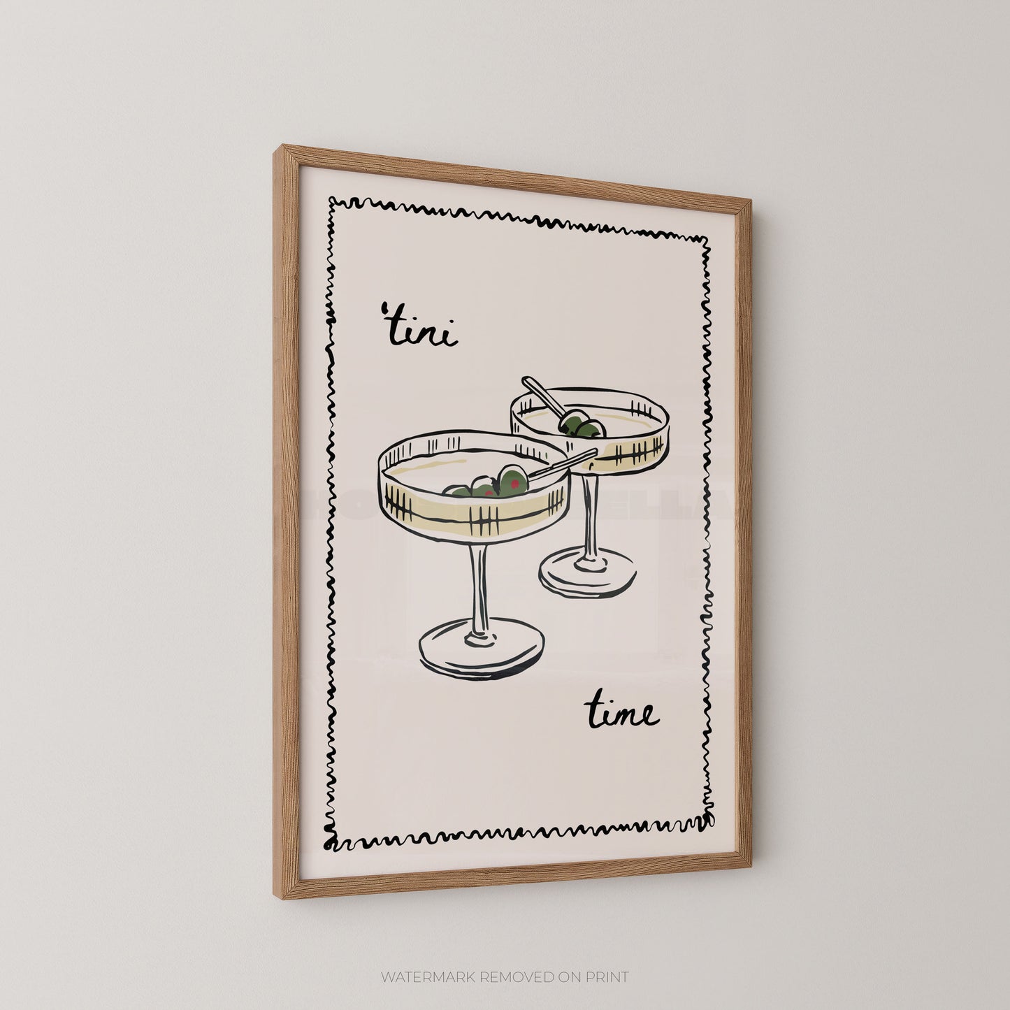 Framed wall art print featuring a minimalist illustration of two cocktail glasses with olives and the words 'tini time' in black script, shown hanging on a light gray wall.