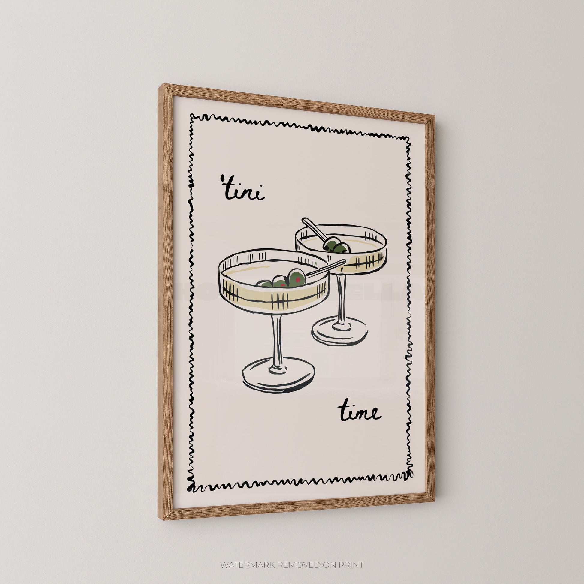Framed wall art print featuring a minimalist illustration of two cocktail glasses with olives and the words 'tini time' in black script, shown hanging on a light gray wall.