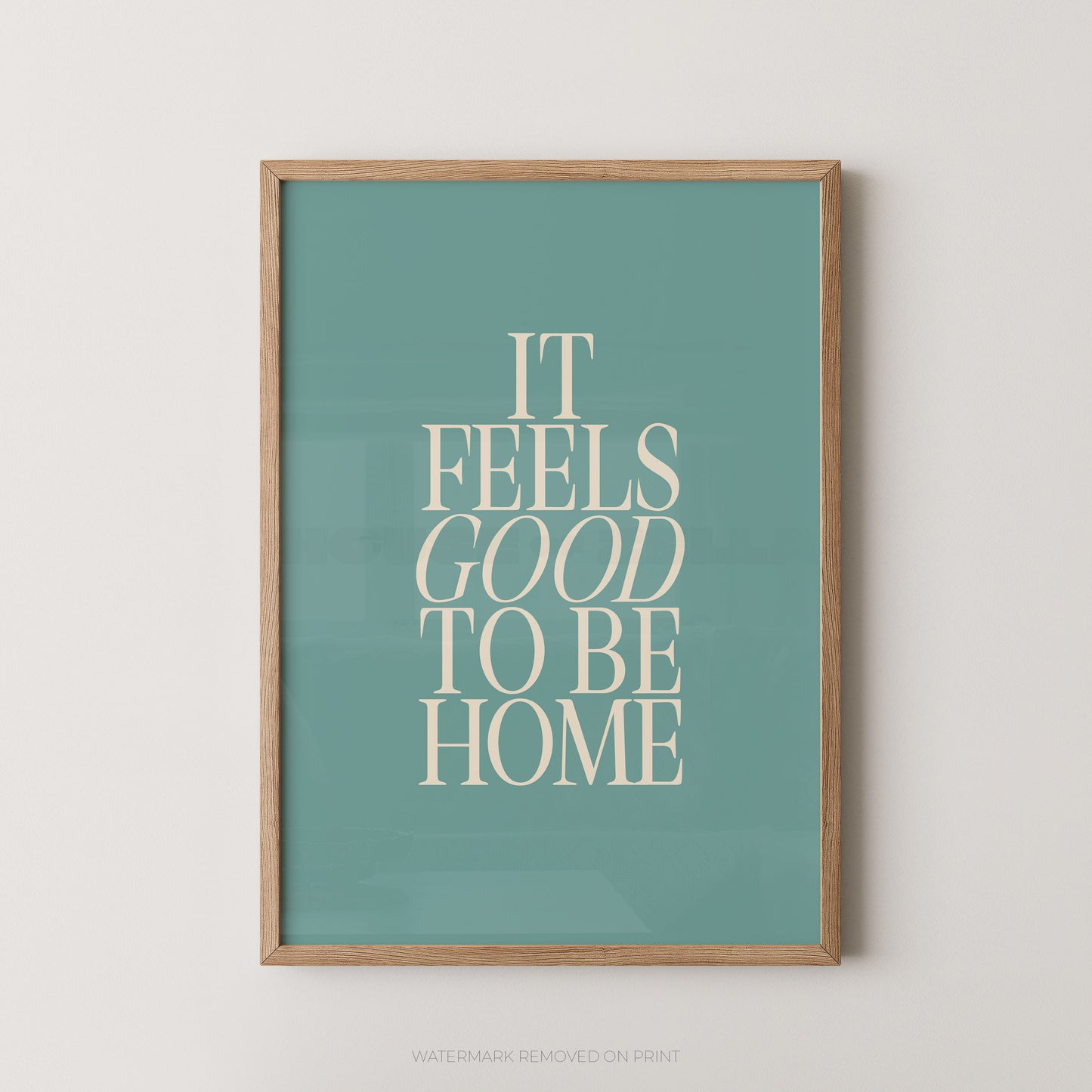"It Feels Good To Be Home typography wall art print with elegant serif lettering in cream on a teal background, displayed straight-on in an oak frame"

