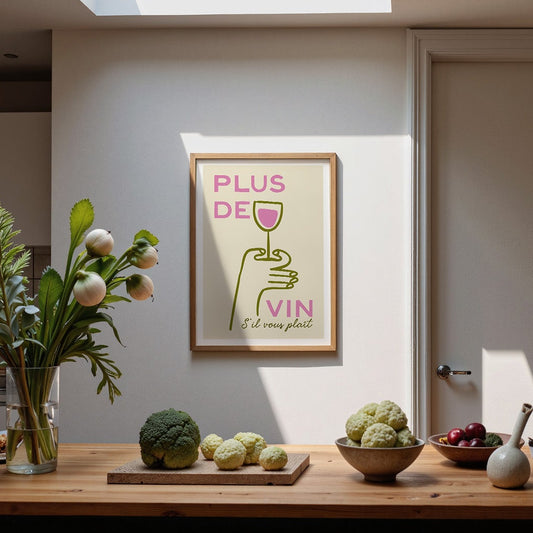 Modern kitchen with wooden table, plants, and a framed poster on the wall.