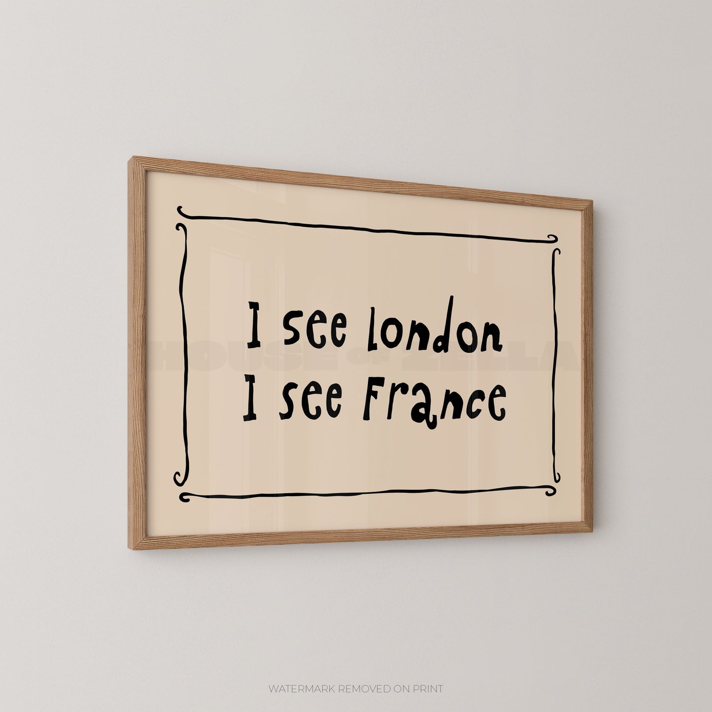 Framed wall art print with the handwritten text 'I see London I see France' inside a simple black decorative border, mounted on a light gray wall.