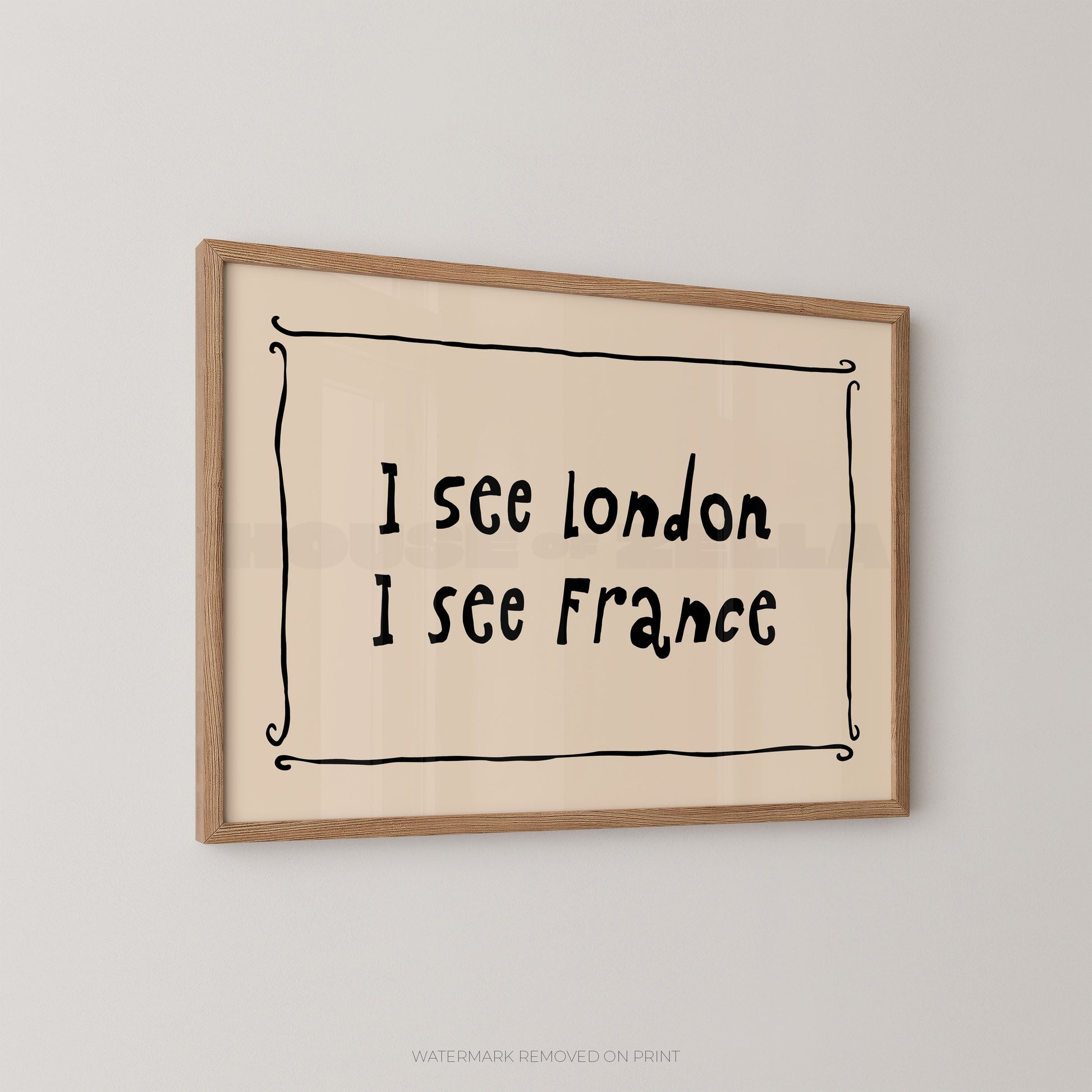 Framed wall art print with the handwritten text 'I see London I see France' inside a simple black decorative border, mounted on a light gray wall.