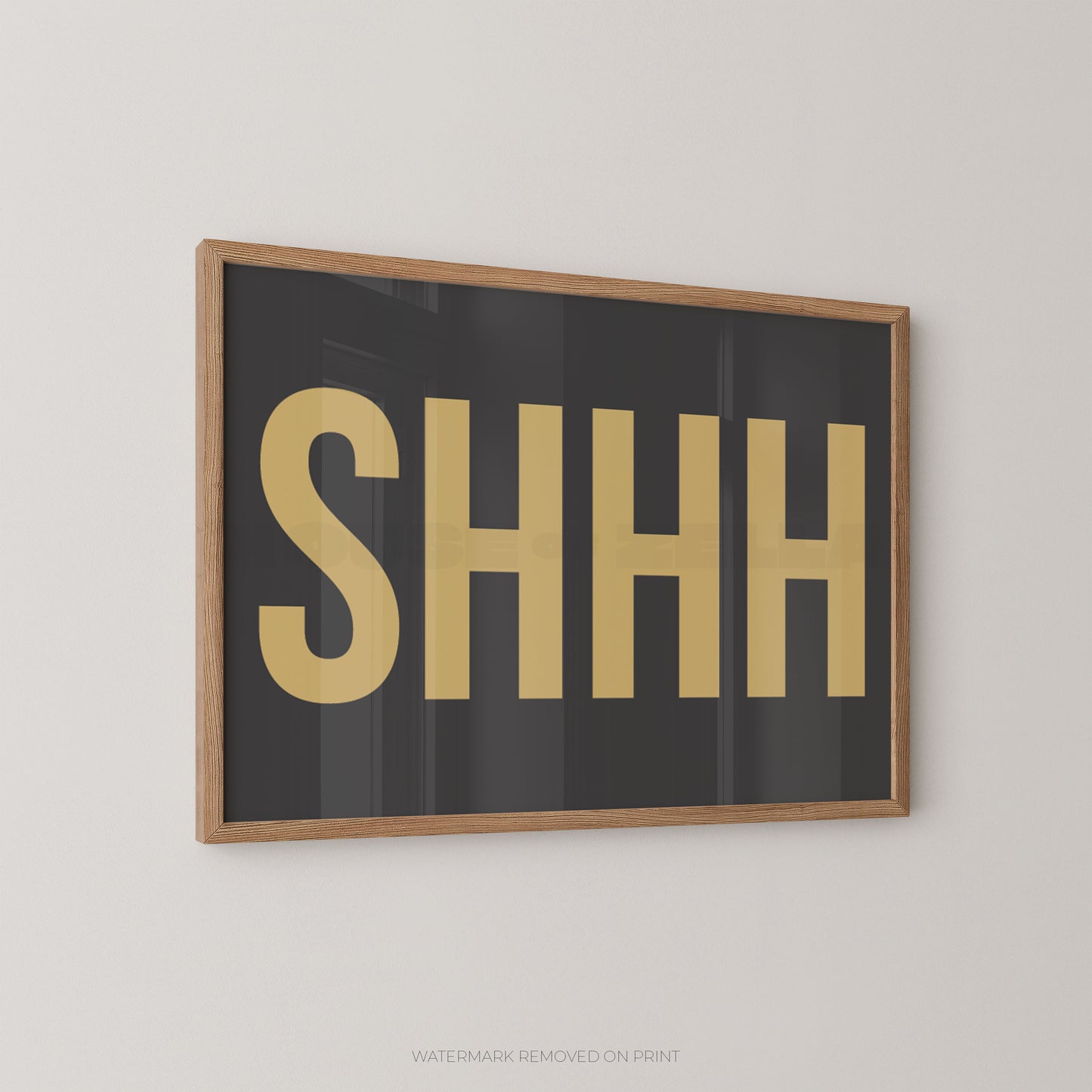 "Shhh bold typography wall art print with yellow lettering on a grey background, displayed at an angle in an oak frame"

