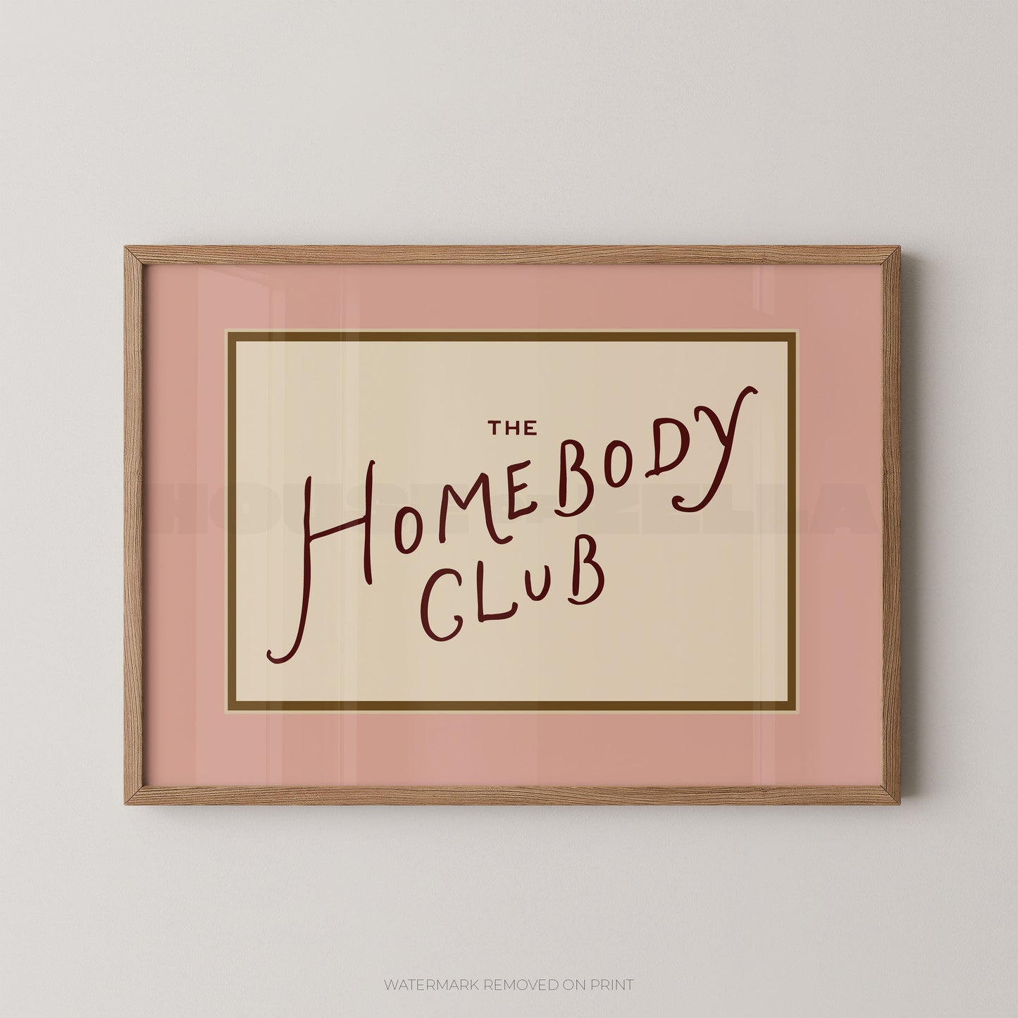 Framed print with 'The Homebody Club' text on a pink background