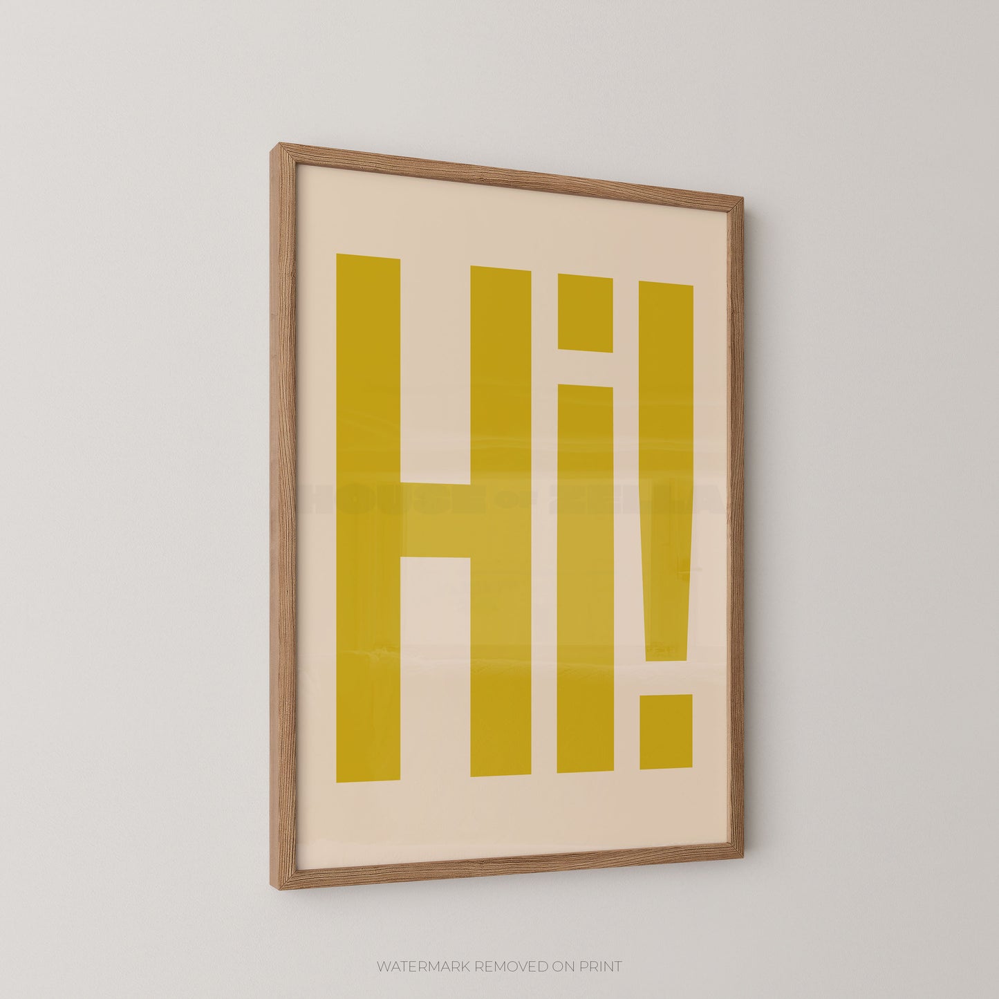 Framed wall art featuring large yellow block letters spelling 'HI!' on a cream background, shown hanging against a light gray wall.