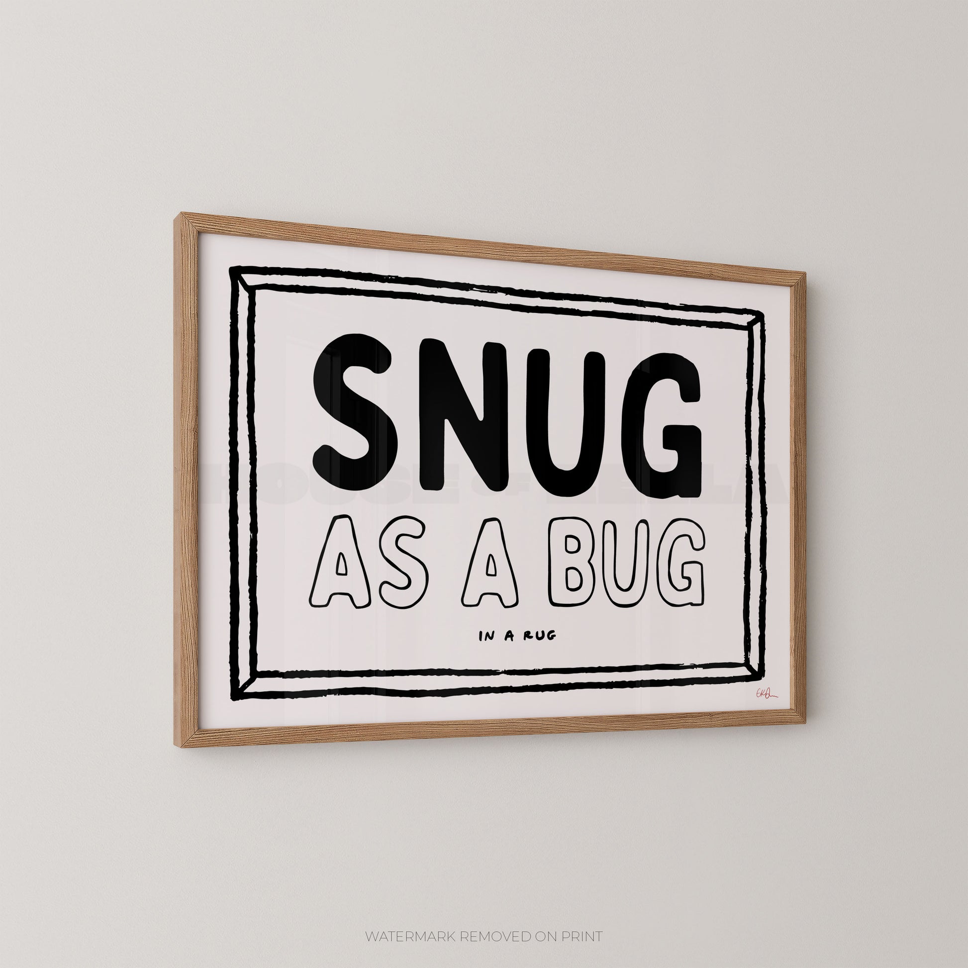 Framed print with 'SNUG AS A BUG' text on a plain wall