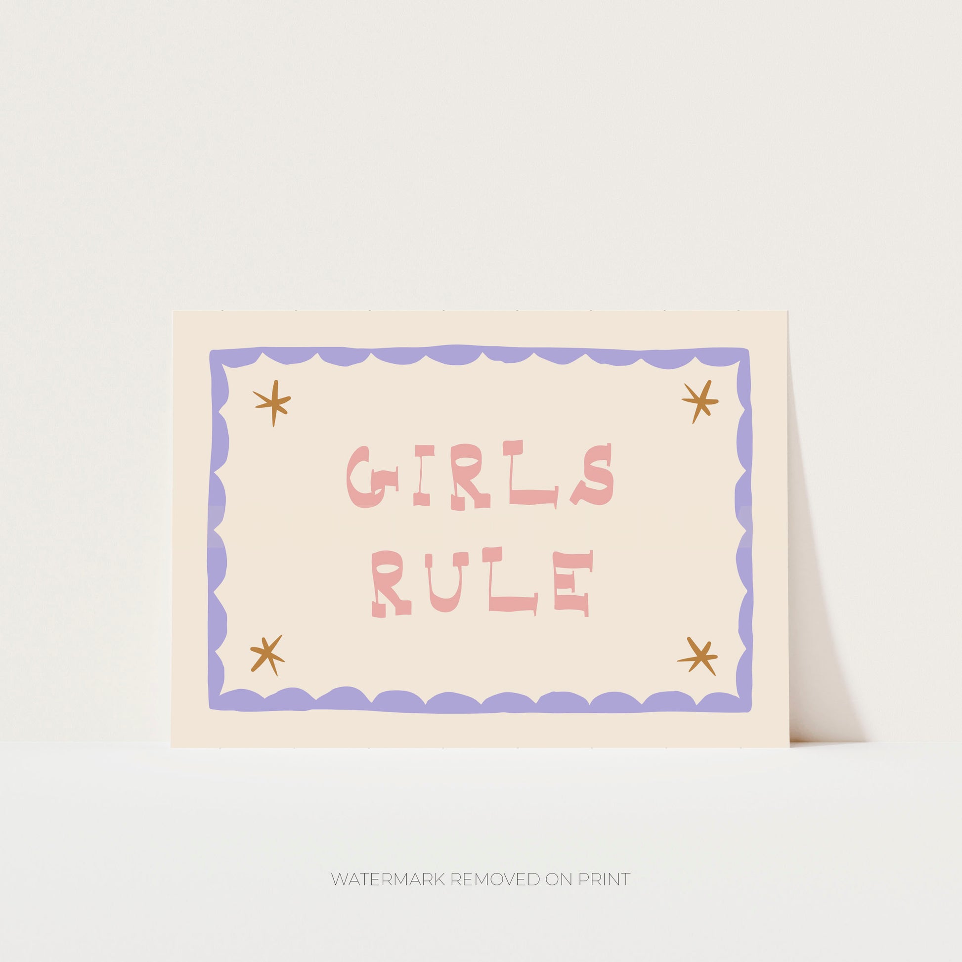 Girls Rule' art print showing pink text on a beige background, with a lilac decorative border and gold stars in the corner.