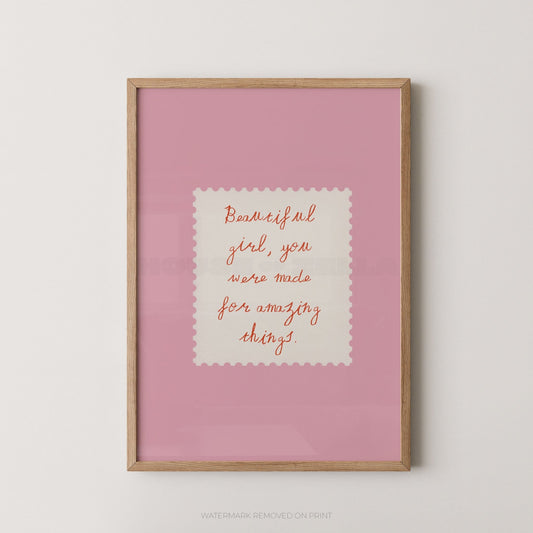Framed pink print with motivational quote on a white wall