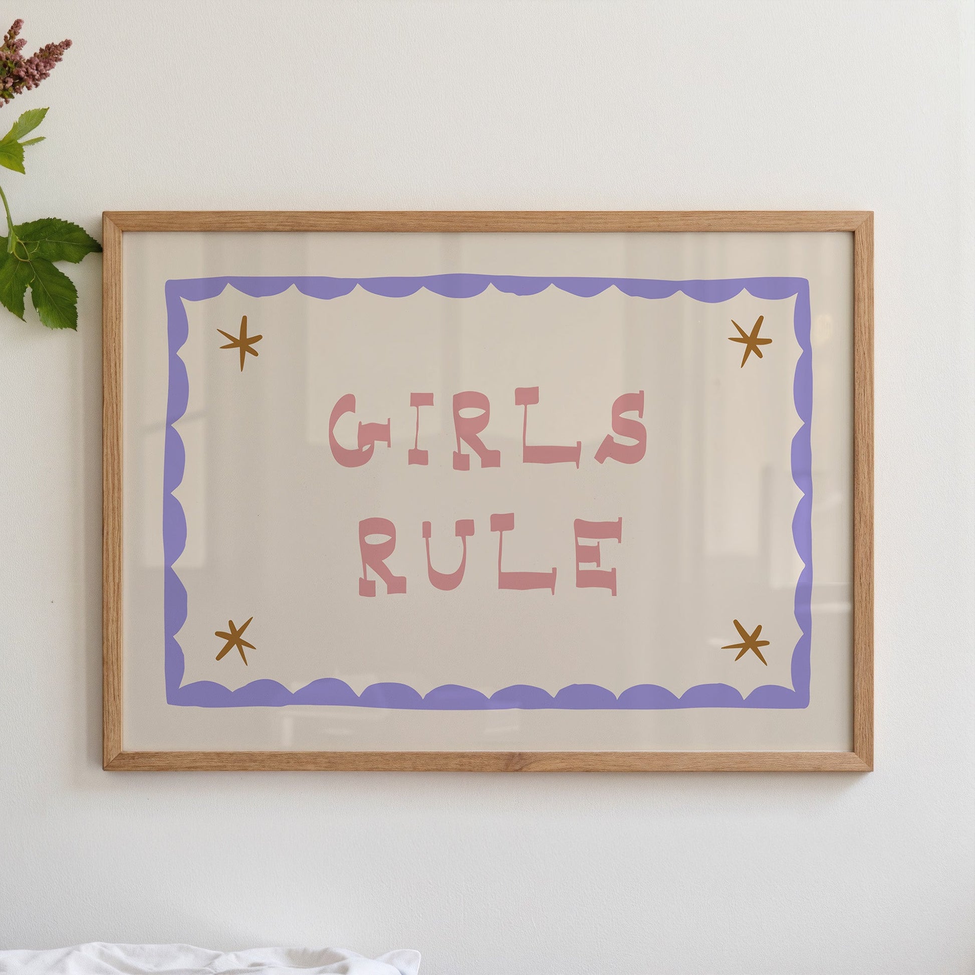 "Girls Rule children's wall art print with bold pink retro lettering on a cream background, purple scallop border with gold star details, displayed straight-on in an oak frame"

