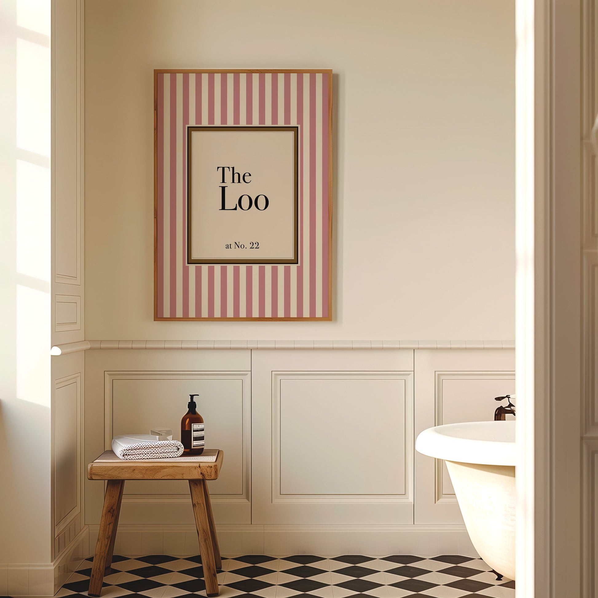 Bathroom interior with a framed picture on the wall, wooden stool, and bathtub.